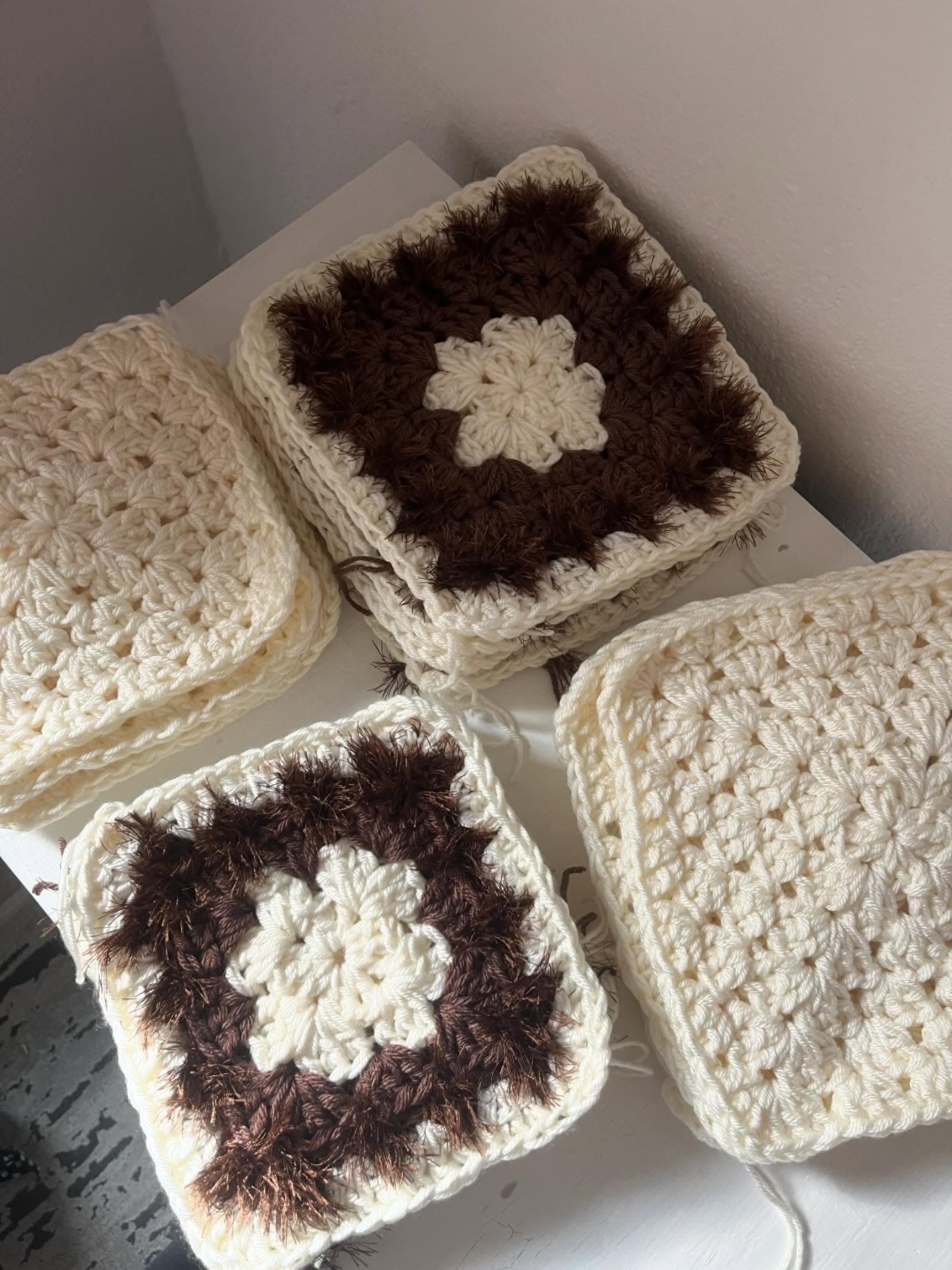 Hand-crocheted granny squares being assembled